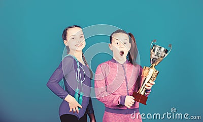 Deserved award. Sport achievement. Girls athletic kids celebrate victory. Athletic girls with golden goblet. Win Stock Photo