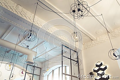 Design of contemporary restaurant ceiling. Foyer pendants. Loft lights. Interior of cafe. Stock Photo