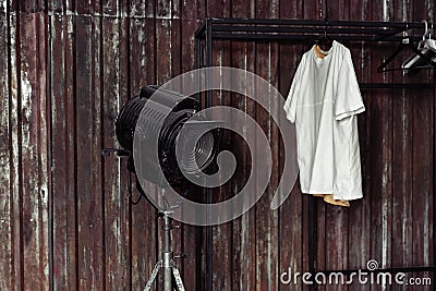 Design of loft Interior of dressing room. Metal wall and cinema lightning and white t-shirt on background. Copyspace for Stock Photo