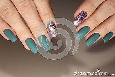 The design of the manicure is green with silver. Stock Photo