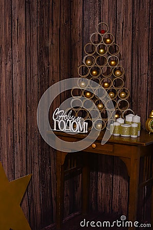 Designer Christmas tree on the table on a wooden background with large white candles Stock Photo