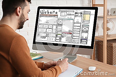 Designer creating website on computer at wooden table Stock Photo