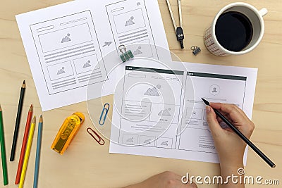 Designer drawing website wireframes on wooden desk Stock Photo