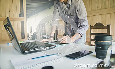 Designer of Graphic creative holding Mouse pen and working on laptop in office,Sunset background,Selective focus Stock Photo