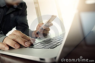 Designer hand working and smart phone and laptop on wooden desk Stock Photo