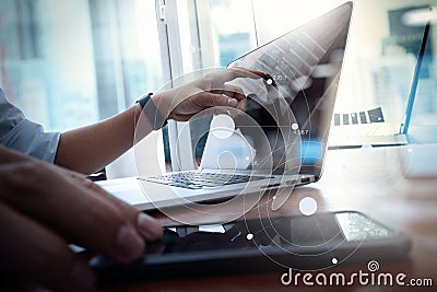 Designer hand working and smart phone and laptop on wooden desk Stock Photo