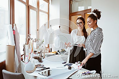 Project manager consultates young designer. Two women in design studio Stock Photo
