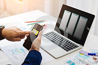 Designer man mobile application test new app features. He working with computer and mobile phone. User experience Design concept Stock Photo