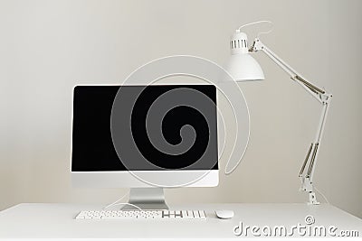 Designer workspace on grey background. Minimalistic home office. Copy space. Keyboard, mouse, computer display with black blank Stock Photo