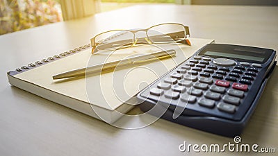 The desk have empty notebook, eyeglasses and calculator Stock Photo