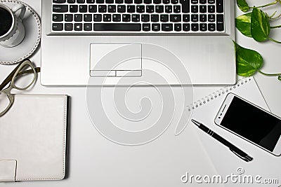 Office desk table top view and supplies, laptop, cup of black coffee, glasses, plant, cellphone on white background. Stock Photo