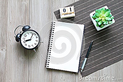 Desk table with open notebook paper, cube calendar and clock Stock Photo