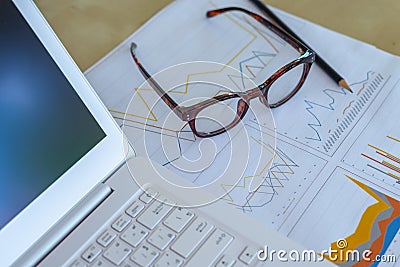 desk workplace, closeup eyeglasses, laptop, pencil and report gr Stock Photo