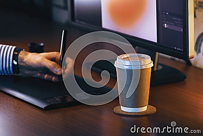 Desktop with computer, graphics tablet and a cup of coffee. Side view Stock Photo