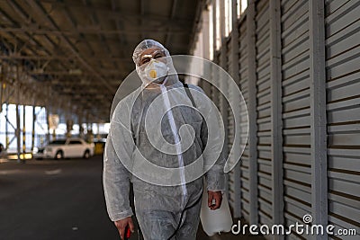 Despair healthcare worker in white covid protective overalls. Tired Male caucasian doctor grabs his head cower in depression Stock Photo