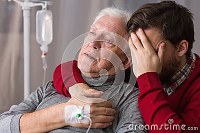 Despair son assisting dying father Stock Photo