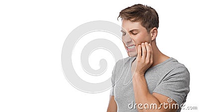 Despaired millennial european man suffering from toothache, press hand to jaw, show displeasure Stock Photo