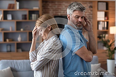 Despaired sad middle aged european male ignores offended woman in living room interior, back to back Stock Photo