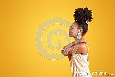 Despaired sad millennial black lady presses hand to elbow, suffer from pain, isolated on orange background Stock Photo