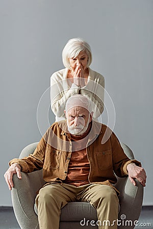 Despaired senior woman touching face while Stock Photo