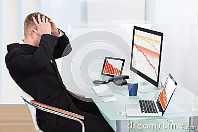 Despairing businessman faced with financial losses Stock Photo