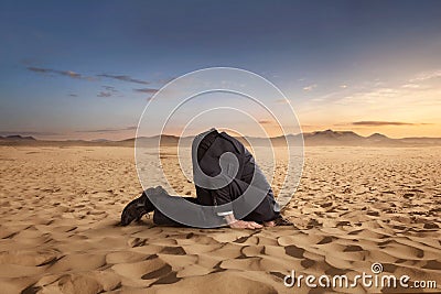 Desparate businessman hiding head in the sand Stock Photo