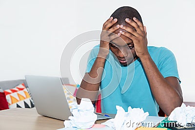 Desperate african american man at desktop at home Stock Photo