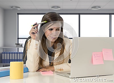 Desperate businesswoman suffering stress at laptop computer desk looking worried Stock Photo