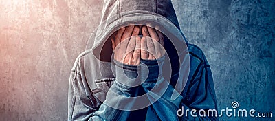 Desperate man in hooded jacket is crying Stock Photo