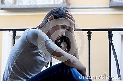 Desperate sad Latin woman at home balcony looking devastated and depressed suffering depression Stock Photo