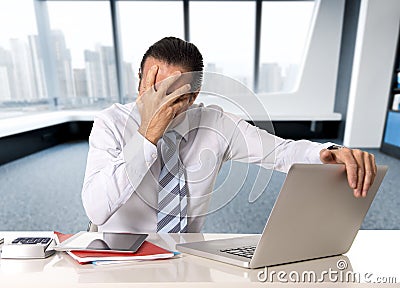 Desperate senior businessman in crisis working on computer laptop at office desk in stress under pressure Stock Photo