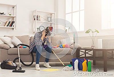 Desperate woman cleaning house with lots of tools Stock Photo