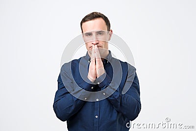 Desperate young man showing clasped hands, asking for help Stock Photo