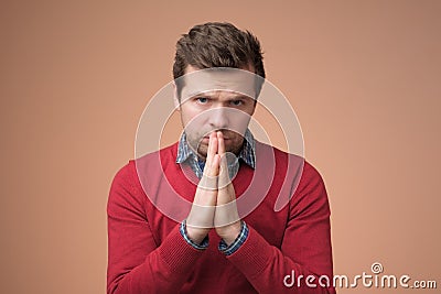 Desperate young man showing clasped hands, sorry for mistake Stock Photo