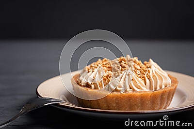 Dessert basket with caramel decorated with gold balls on a black wooden table near a fork with three prongs Stock Photo