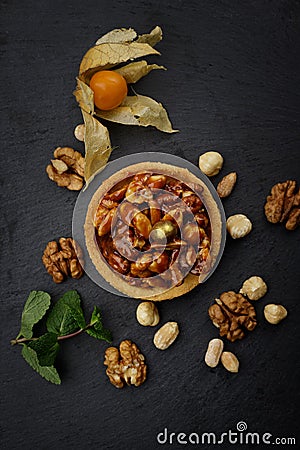 Dessert basket with nuts and caramel, on a black stone Stock Photo