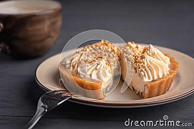 Dessert basket with salted caramel placed on a plate and cut, served with cappuccino Stock Photo