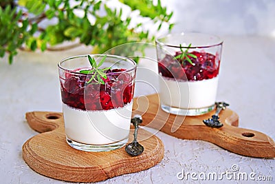 Dessert, creamy panna cotta with cherry sauce in glass glasses on a light concrete background. Desserts without baking. Desserts Stock Photo