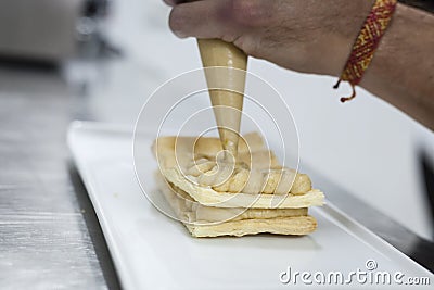 Dessert elaboration and plating on a restaurant kitchen. Stock Photo