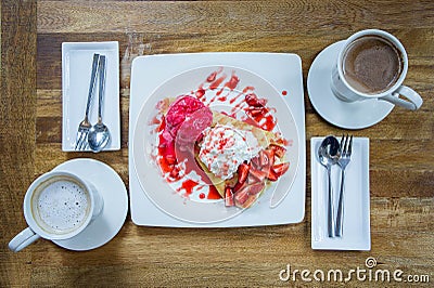 Dessert ice cream strawberry crepe and hot drink in coffee shop Stock Photo