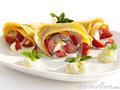 A dessert plate with pancakes, strawberry, whipped cream and mint Stock Photo