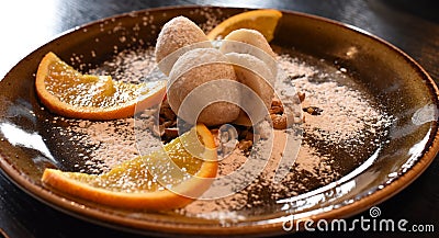 A dessert rice balls, ice cream ball and pieces of fruits served on a dark plate Stock Photo