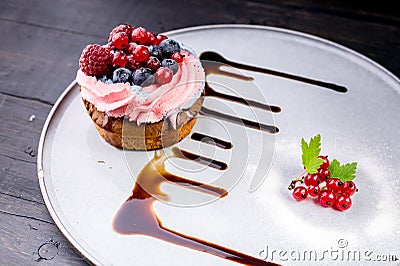 Dessert tart with cream, honey and fresh berries on a white plate. Close up. Delicious treat Stock Photo