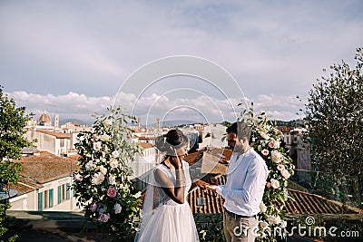Destination fine-art wedding in Florence, Italy. Multiracial wedding couple. A wedding ceremony on the roof of the Stock Photo