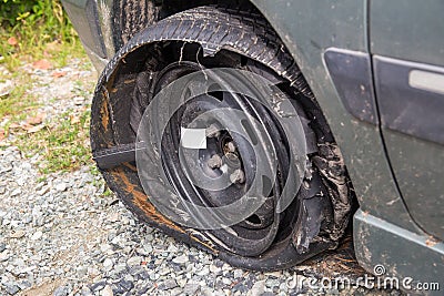 Destroyed blown out tire with exploded, shredded and damaged tire on a modern automobile. Stock Photo