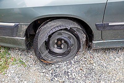Destroyed blown out tire with exploded, shredded and damaged tire on a modern automobile. Stock Photo