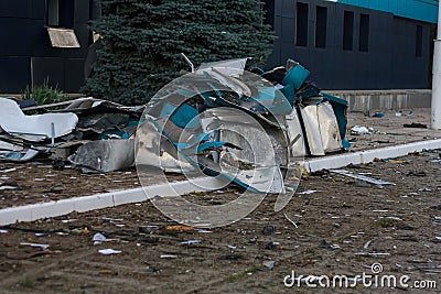 Destroyed civil infrastructure building, pile of fragments and broken glass in front of it. Military drones attack aftermath Stock Photo