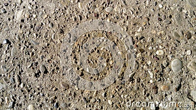 Destroyed concrete pavement. Small stones of different colors come out. A play of light and shadow on an uneven surface is created Stock Photo