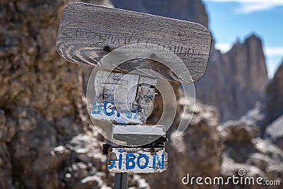 A destroyed and illegible sign standing on a trail in the Dolomites Stock Photo