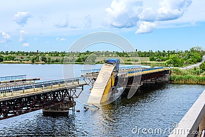 Destruction of bridge structures across the river with the collapse of sections into the water Stock Photo